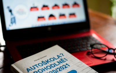 Učební materiály a testy autoškoly na stole.