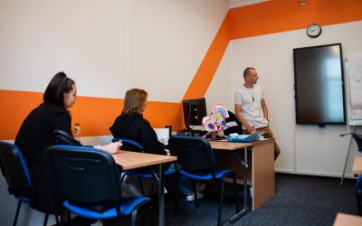 Učebna autoškoly s lavicemi a studenty.