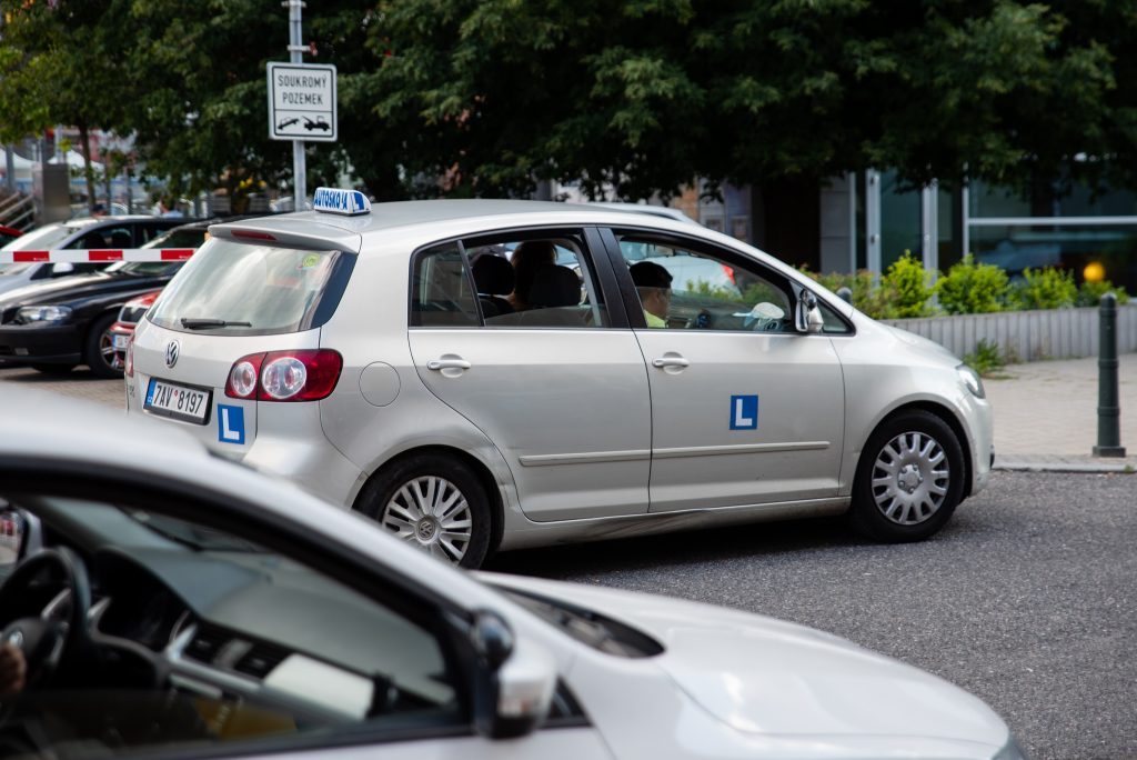Výcvikové vozidlo autoškoly zaparkované u silnice.
