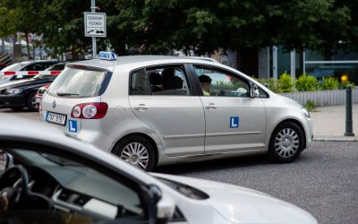 Výcvikové vozidlo autoškoly zaparkované u silnice.